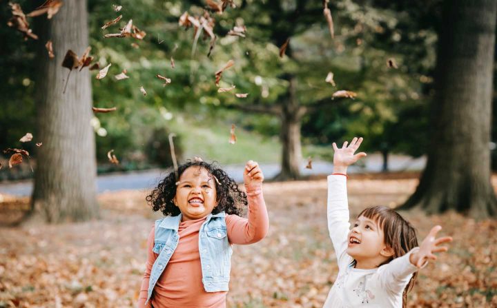 Kinderen spelen buiten met bladeren - Foto door Charles Parker van Pexels